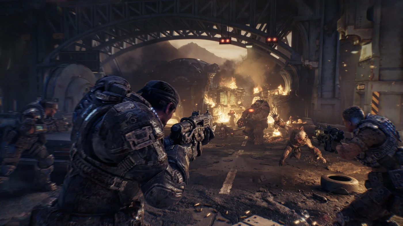Official Gears of War: E-Day gameplay screenshot showing a squad taking cover behind wrecked vehicles while fighting Locust enemies, including a large armored Boomer